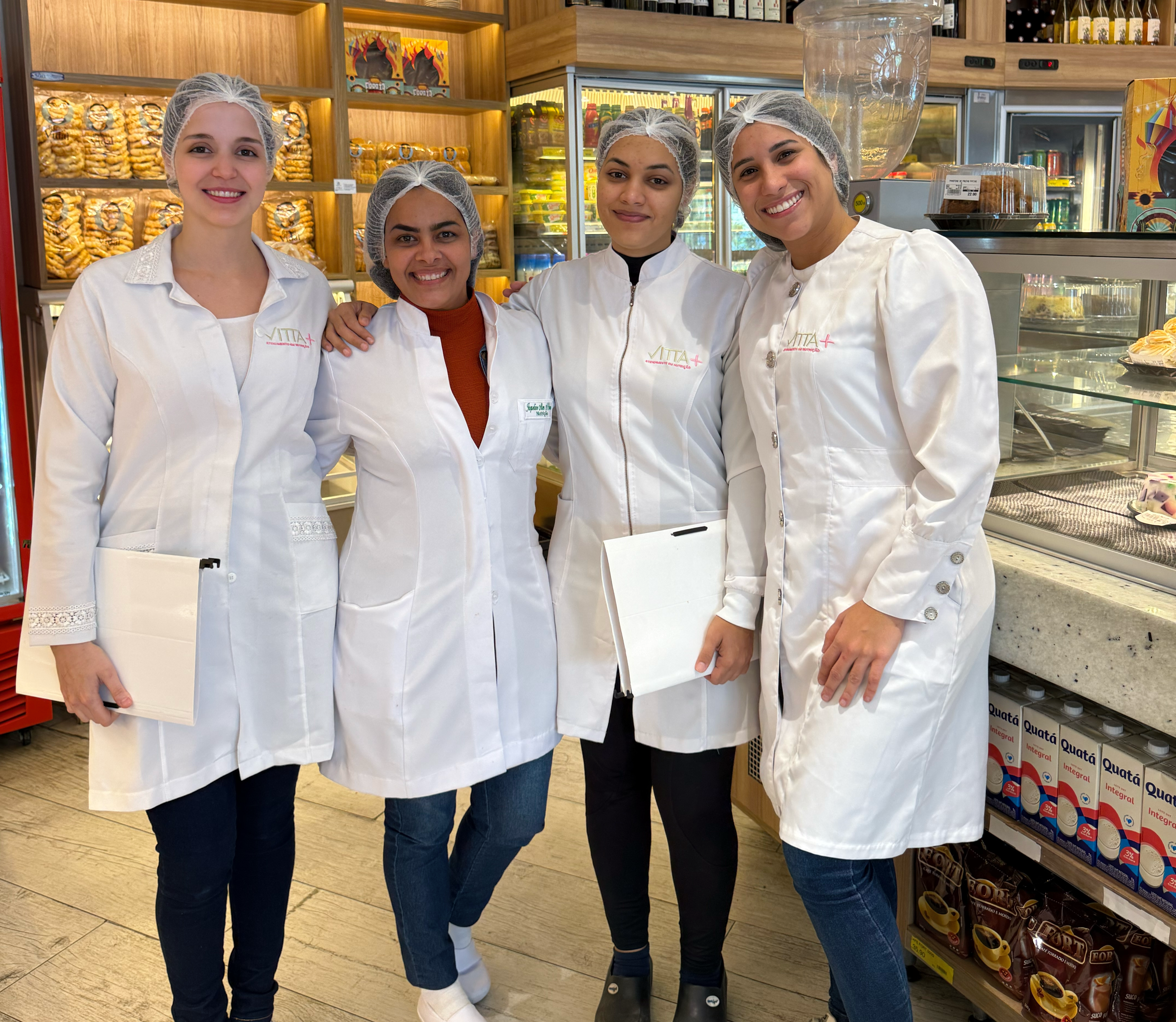 Equipe Vitta+ em ambiente de Consultoria de alimentos, com jalecos e toucas